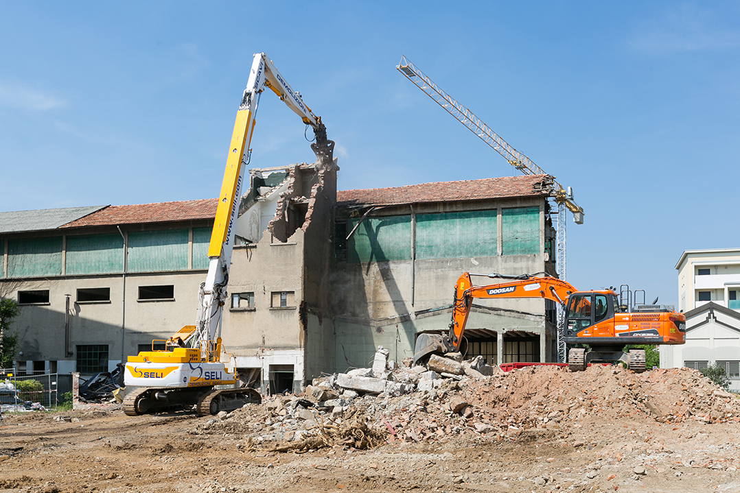 L’escavatore da demolizione Doosan DX530DM abbatte lo storico stabilimento Brugola OEB